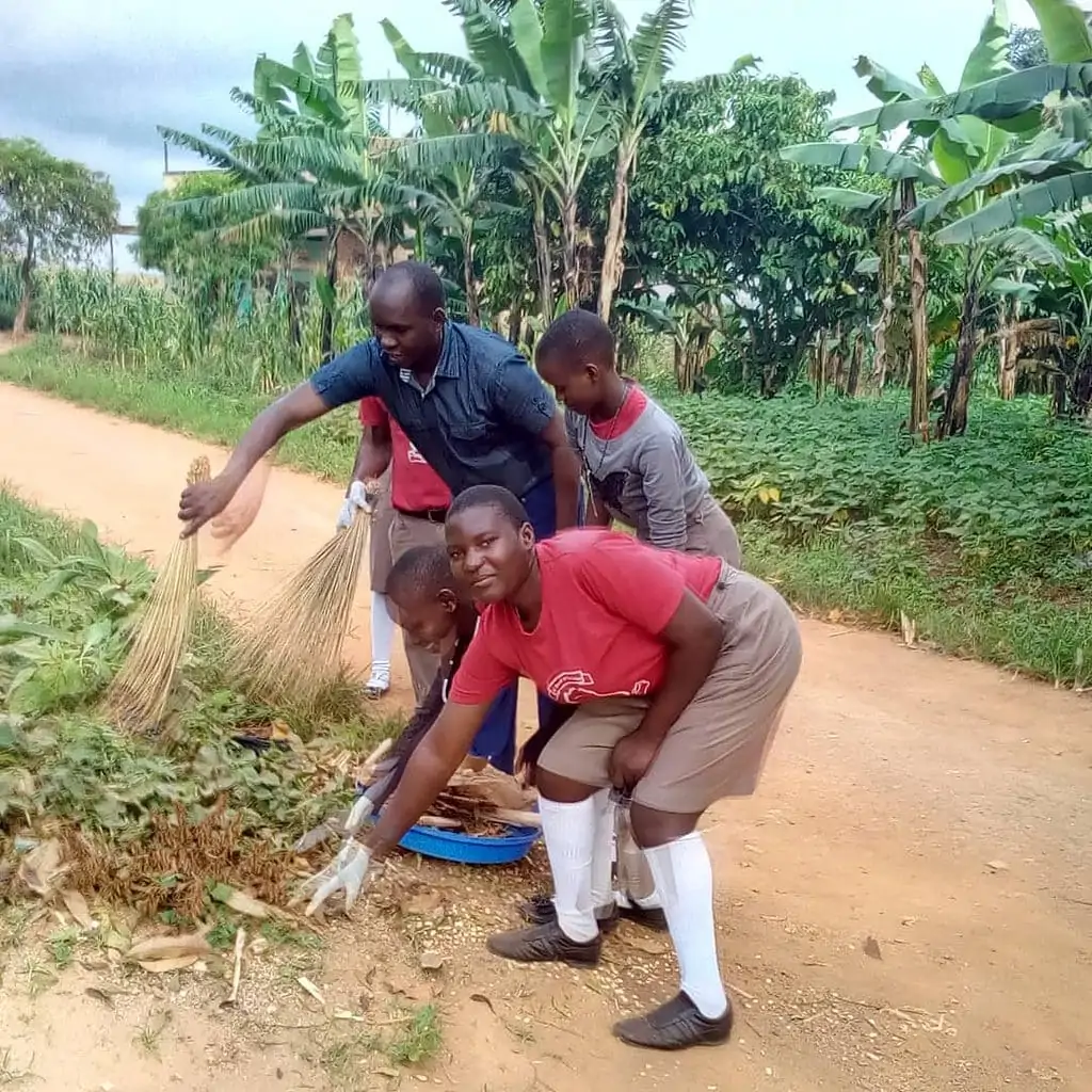 Students & Headteacher cleaning a street